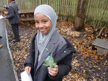 A pupil holds a leaf