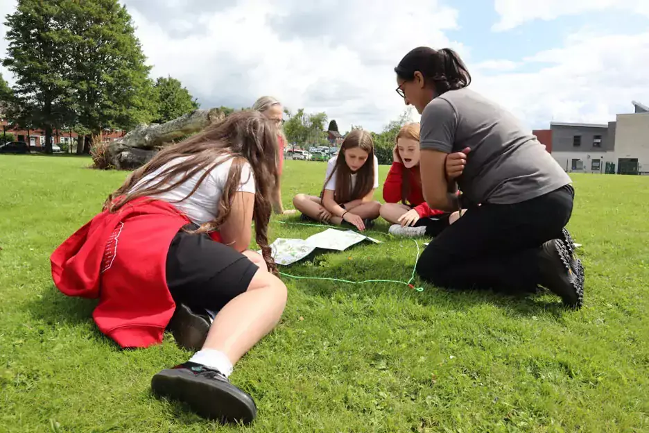 Students and teacher observe nature on their school field