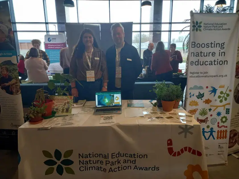 Nature Park team members at an event, standing in front of stall with banner