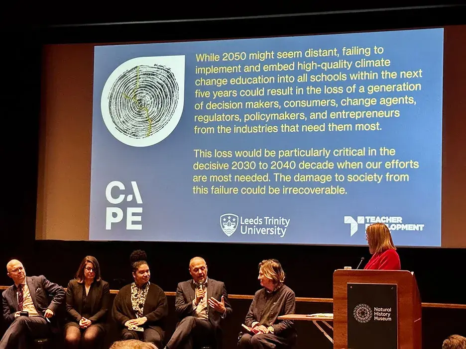 Speakers sit in front of a screen at a CAPE presentation