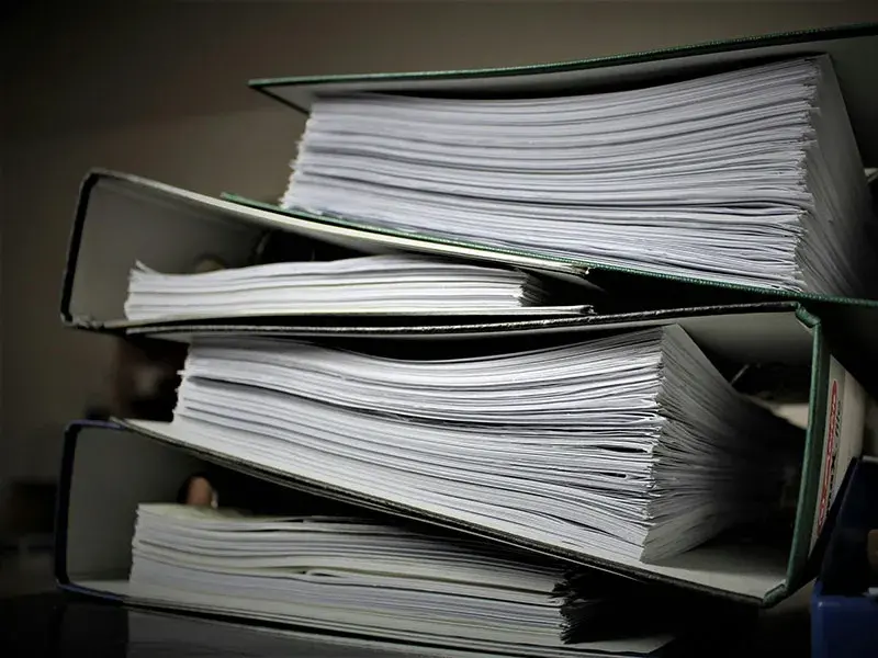 A stack of paper files in ring binders